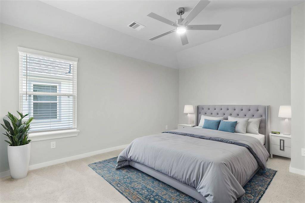 Secondary bedroom features plush carpet, custom paint, ceiling fan with lighting, large window with privacy blinds, and its own private vanity into shared jack-n-jill bathroom.