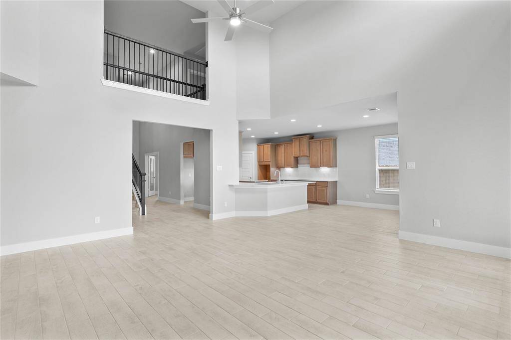 Secondary bedroom features plush carpet, custom paint, ceiling fan with lighting and a large window with privacy blinds.