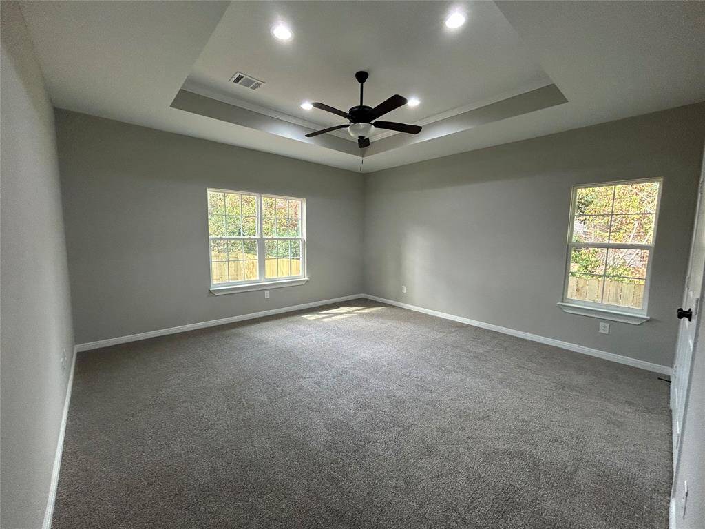 Spacious and private, this primary retreat has two large windows, filling the room with natural light from both sides!  The recessed ceiling adds a touch of sophistication, making the large space feel even more open!