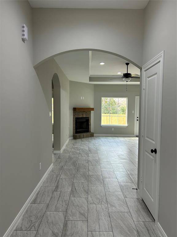 This entryway welcomes you in with a graceful arched passage, leading into a bright and open living space. The sleek modern tile flooring enhances the sense of elegance, while the neutral tones provide a warm and inviting canvas for any style!