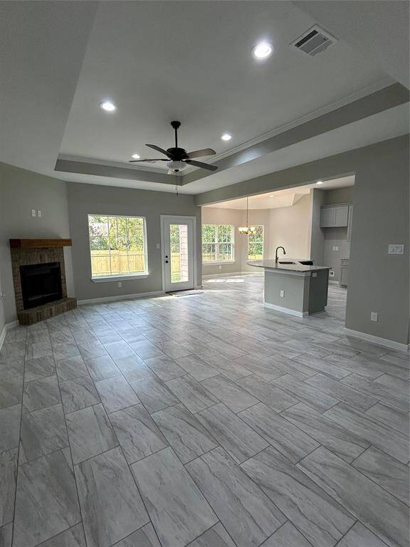 Welcome to your living room! This bright and open space features a beautiful recessed ceiling with a cozy fireplace. Big windows flood the room with natural light, creating a bright and inviting atmosphere.