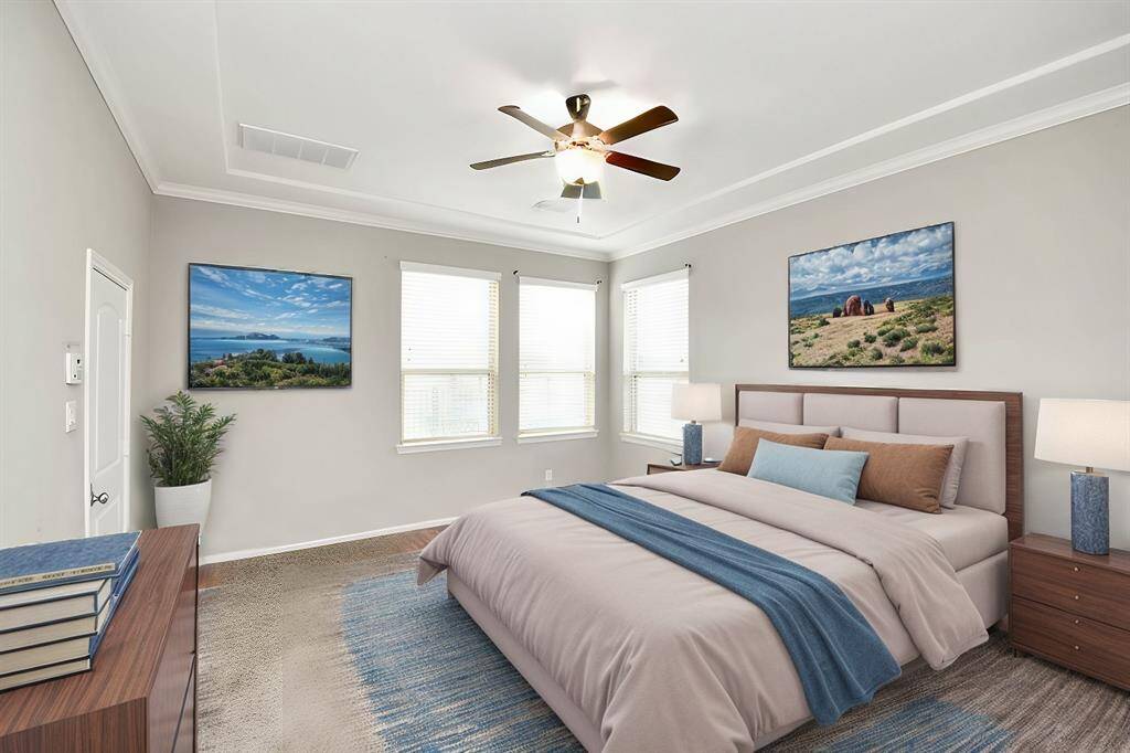 Generous master suite is light and bright and features tiered ceiling with moldings. This image has been virtually staged.