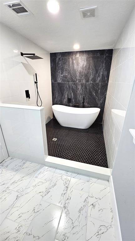 Elegant Primary Bathroom with Matte Black Vanity with Brushed Gold Accents and Modern LED Lighting