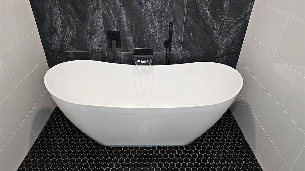 Elegant Primary Bathroom with Matte Black Vanity with Brushed Gold Accents and Modern LED Lighting