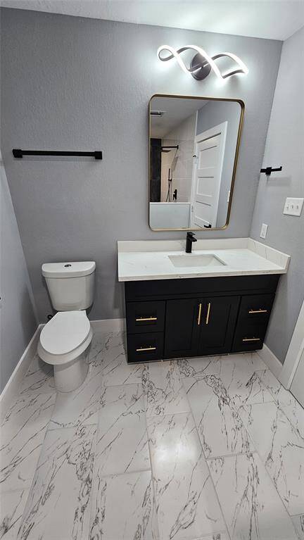Elegant Primary Bathroom with Matte Black Vanity with Brushed Gold Accents and Modern LED Lighting