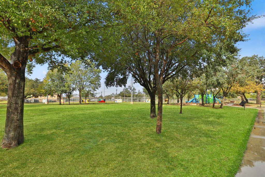 Just around the corner is a spacious park with lush green grass and mature trees providing ample shade ideal for families seeking outdoor recreation and community space near their home.
