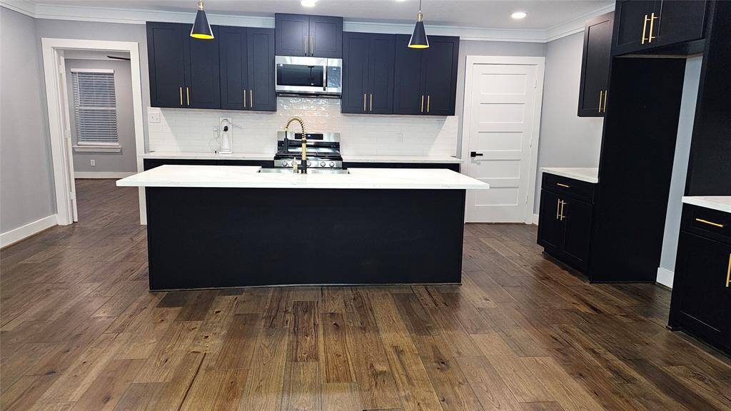 Beautiful Open Concept 30x20 Kitchen, Dining Room and Living Area. Featuring Modern Fireplace, Solid Wood Matte Black Cabinets with Soft Close Doors/Drawers, Stainless Steel Samsung Smart Appliances, Brushed Gold Hardware and Lighting