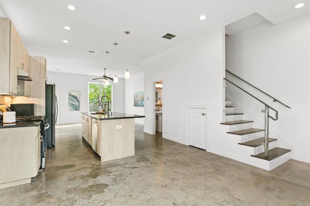 Open concept living area flows to gourmet island kitchen. The living area has recessed lighting and there are polished concrete floors throughout the main level.