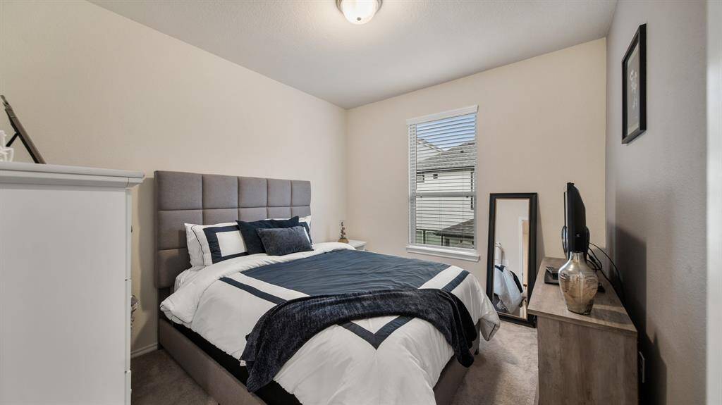Secondary bedroom features awindow and plush carpet.