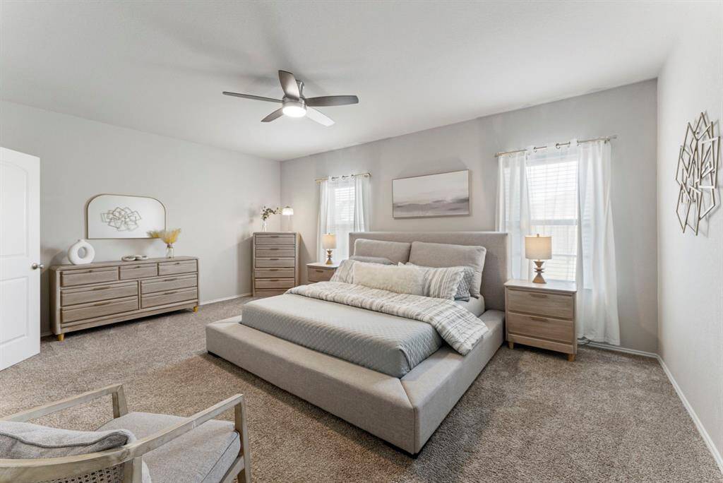 Relax in the spacious primary bedroom, bathed in natural light and painted in soothing neutral tones.