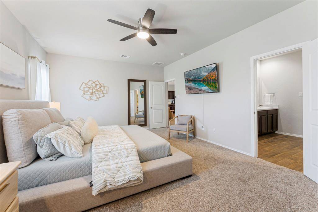 The neutral paint color creates a calming atmosphere, making relaxation easy in this primary suite.