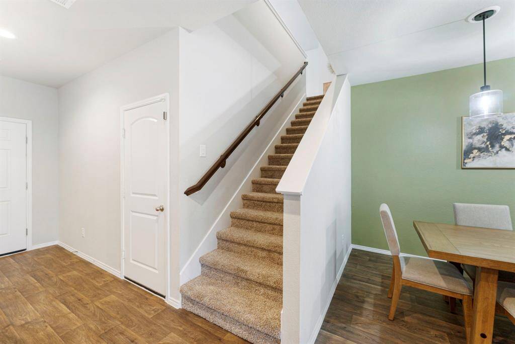 The stairs are located between the garage door and dining room, offering easy access to the upper level.