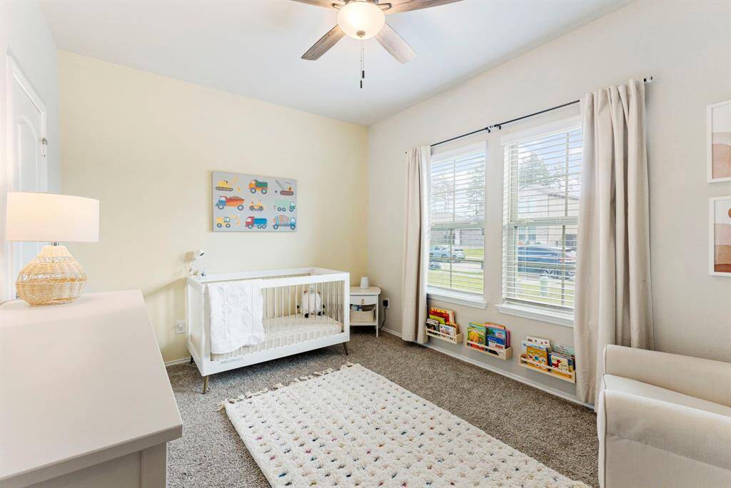 One of the secondary bedrooms is conveniently located downstairs, perfect for a nursery, bedroom, office, or flex space! This bedroom is located down the hall to the right as you enter the home. The fan has been added for comfort & functionality.