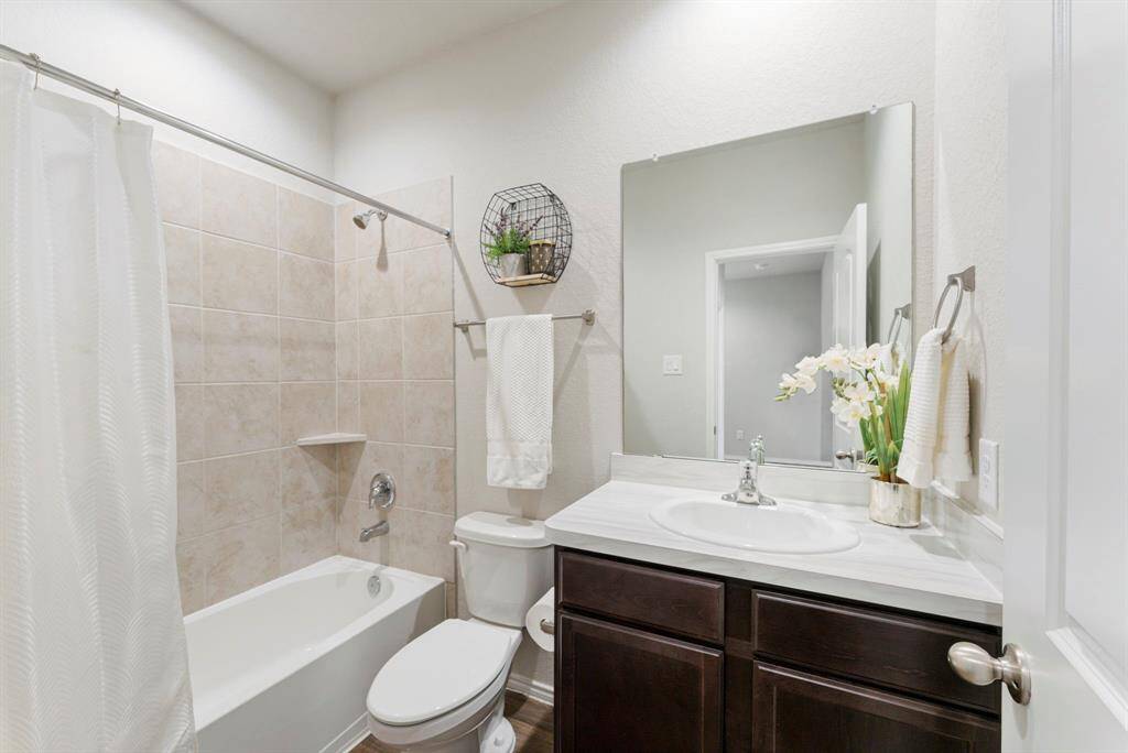 The second full bathroom is located downstairs, adjacent to the secondary bedroom and next to the laundry room.
