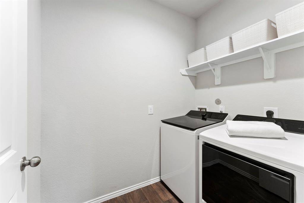 The laundry room is conveniently located across from the secondary bedroom downstairs, offering easy access and great functionality.