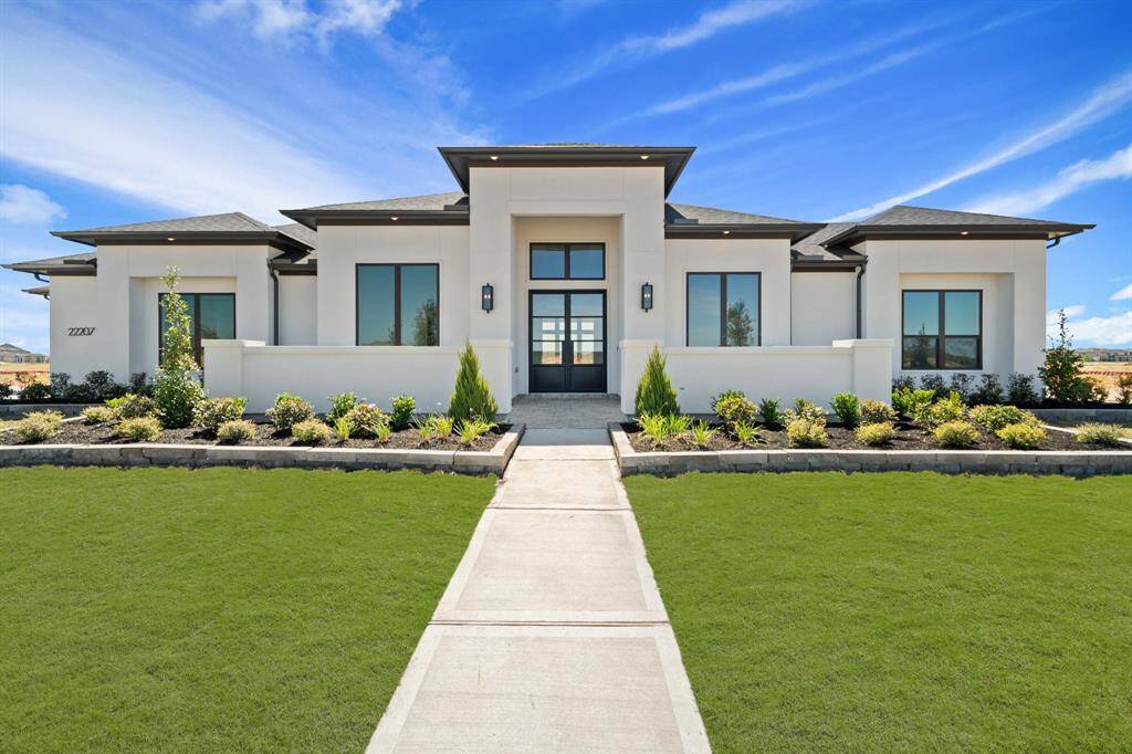 The modern elevation of this FEDRICK HARRIS MEDICI PLAN boasts a sleek and contemporary design. It includes a four-car garage & is surrounded with windows, creating a bright and inviting atmosphere throughout the home.