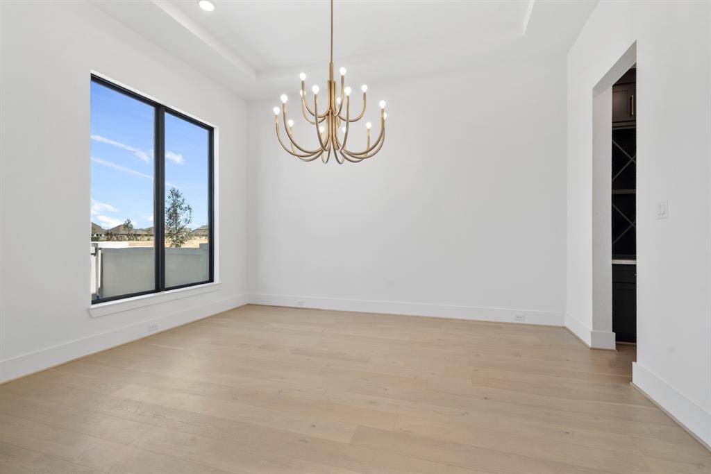 A stylish dining room adorned with a stunning light fixture, creating an inviting and elegant atmosphere for every meal.