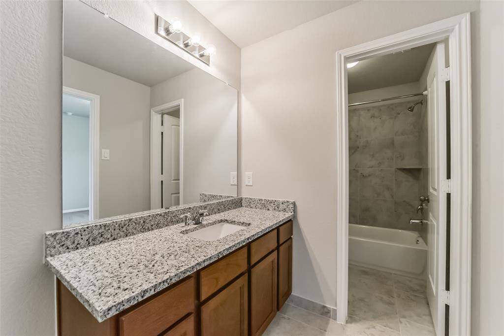 This secondary bath features a tile surround shower/tub combo.