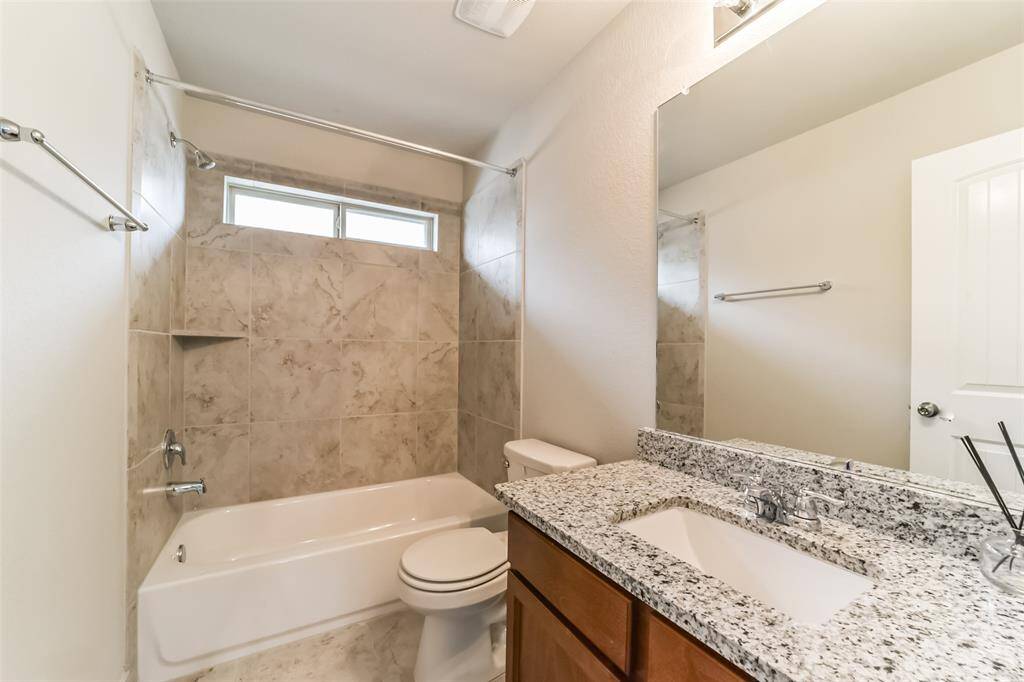 This secondary bath features a tile surround shower/tub combo.