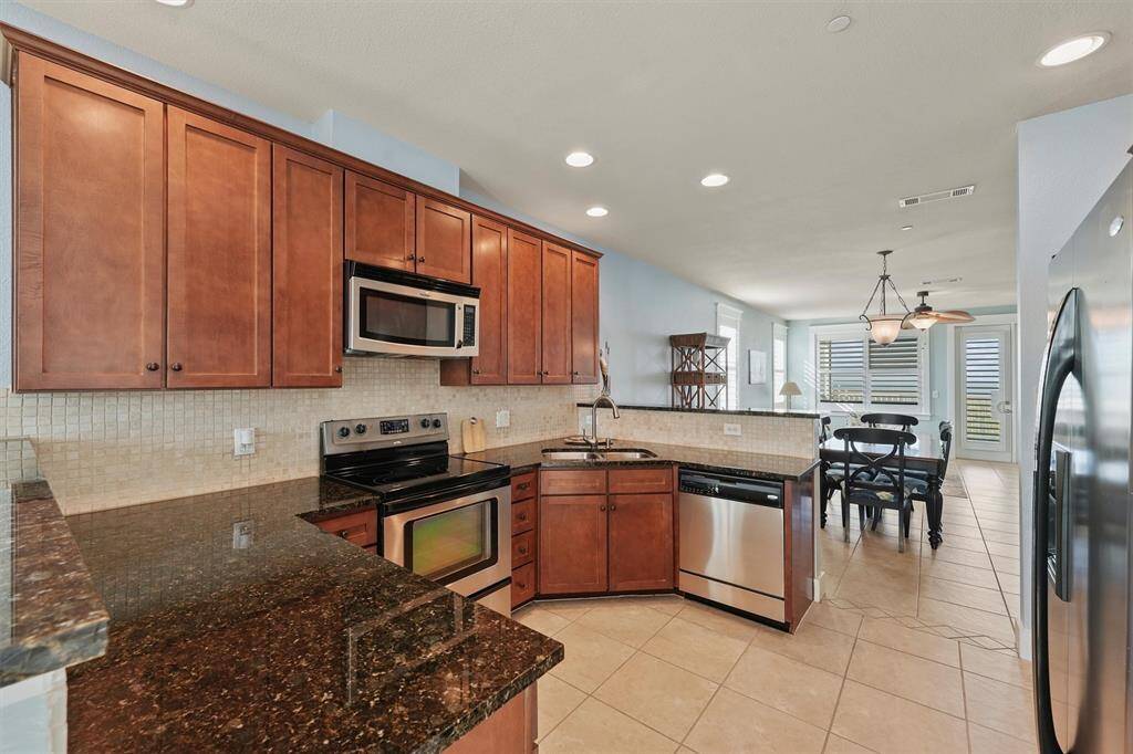 Equipped with stainless steel appliances and a convenient double sink, this fully functional kitchen is designed for both style and efficiency, offering plenty of counter space for meal prep.