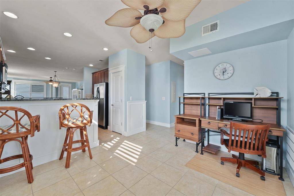 This versatile bonus space features a second breakfast bar and desk, perfect for a home office or study area, with plenty of natural light flowing through large windows.
