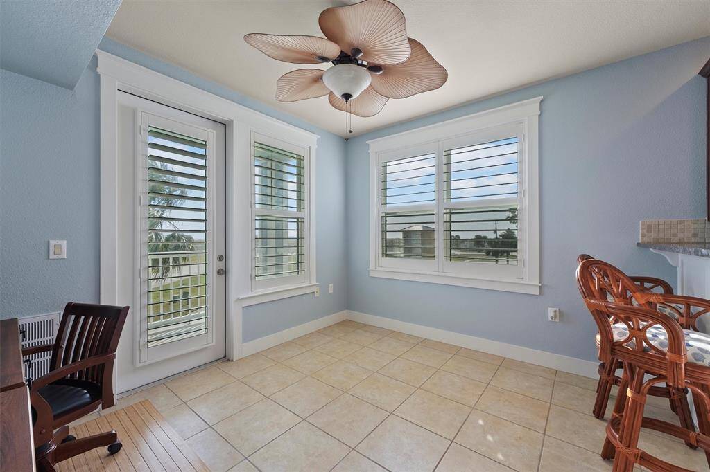 With easy access to the balcony and scenic views, this bonus room offers an ideal spot for a quiet workspace or cozy reading nook, enhanced by a unique fan with petal-shaped blades.