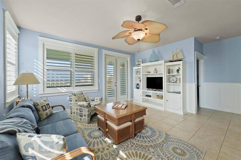 Bathed in natural light, this charming living room invites you to relax and unwind, with double doors leading to a private balcony that captures refreshing bay breezes.