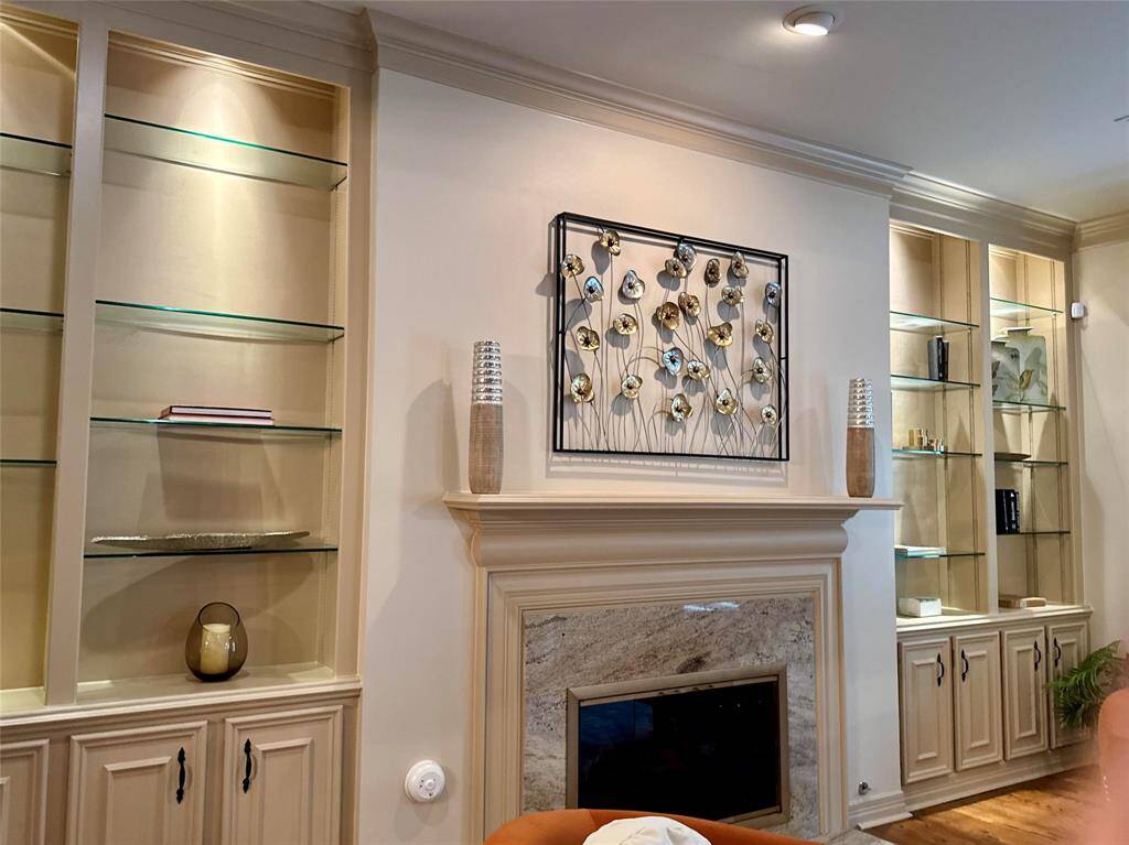 Glass shelves light up on either side of fireplace in Living room
