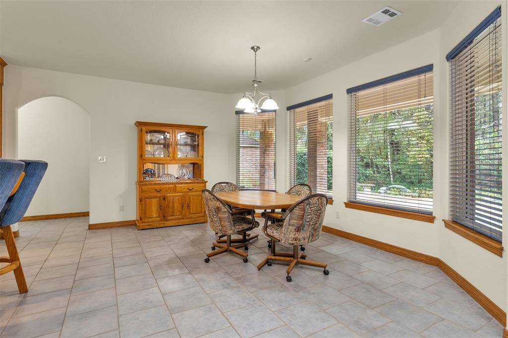 A warm and inviting dining area, ideal for family meals and entertaining guests. Large windows offer serene views, bringing a touch of nature indoors for a charming dining experience.