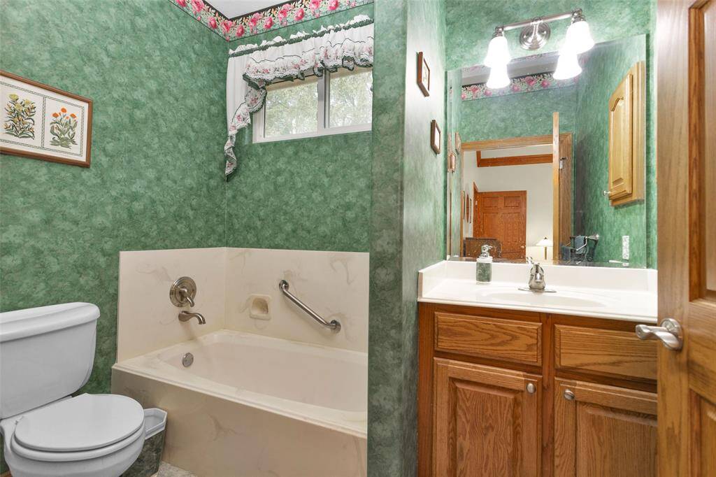 Full bathroom with grab bars in shower.