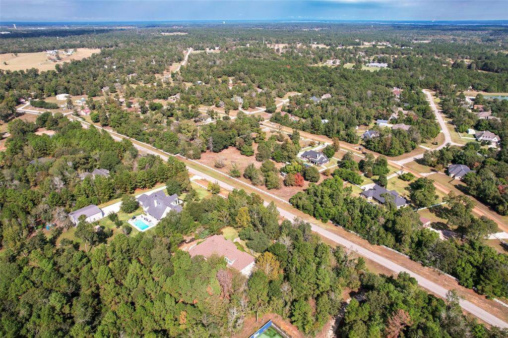 This view reveals the expansive backyard, registered as a certified wildlife habitat. From above, you can see the well-maintained landscape, mature trees, and natural elements that make this outdoor space a haven for nature lovers.