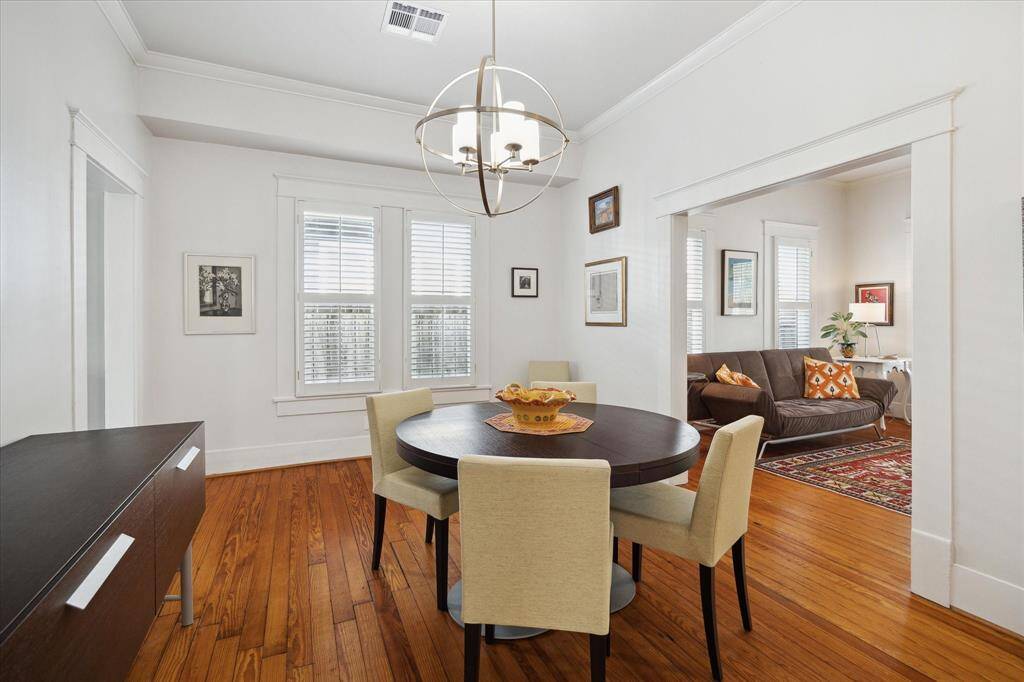 The dining room features crown molding, plantation shutters and is convenient to the living room, kitchen, and primary bedroom. We love the beautiful chandelier!