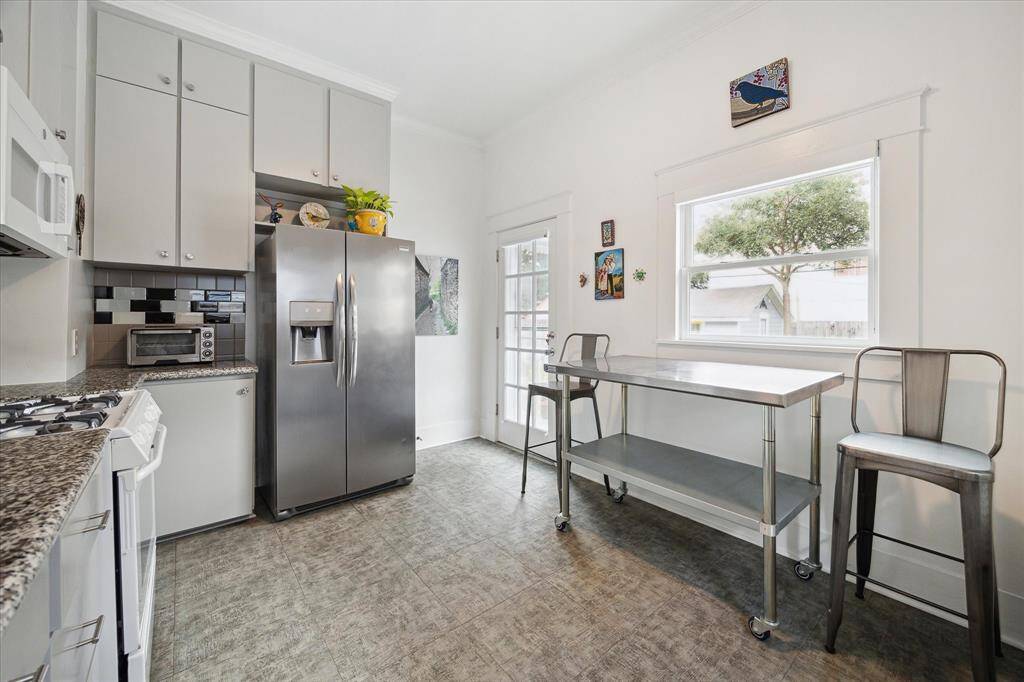 The charming, spacious, remodeled kitchen is light and bright, with space to accommodate a breakfast table or seating area. We love the large window and the door leading to the backyard!