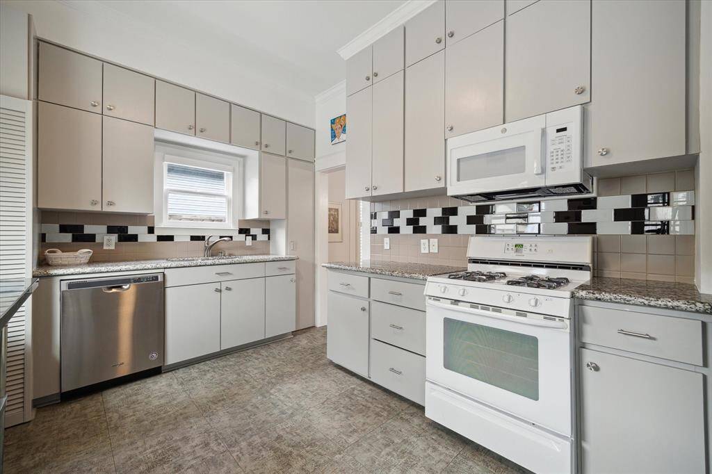 Another view of the kitchen, showcasing the lovely window above the sink and the fantastic cabinetry!