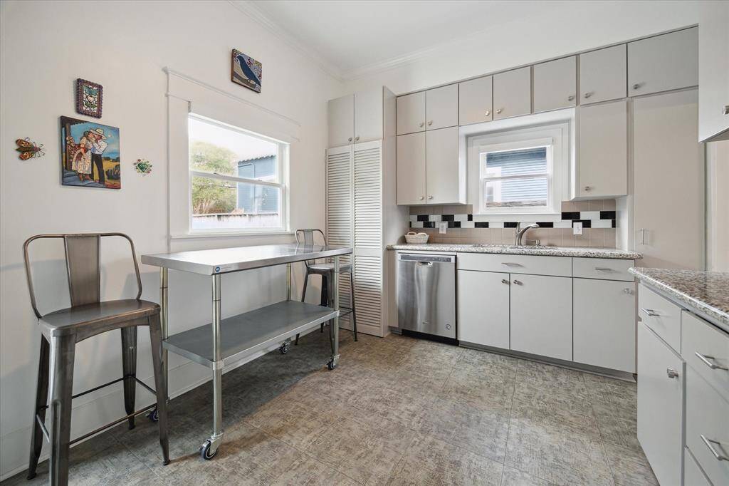 Just beside the dishwasher, double doors open to reveal the hidden washer and dryer!