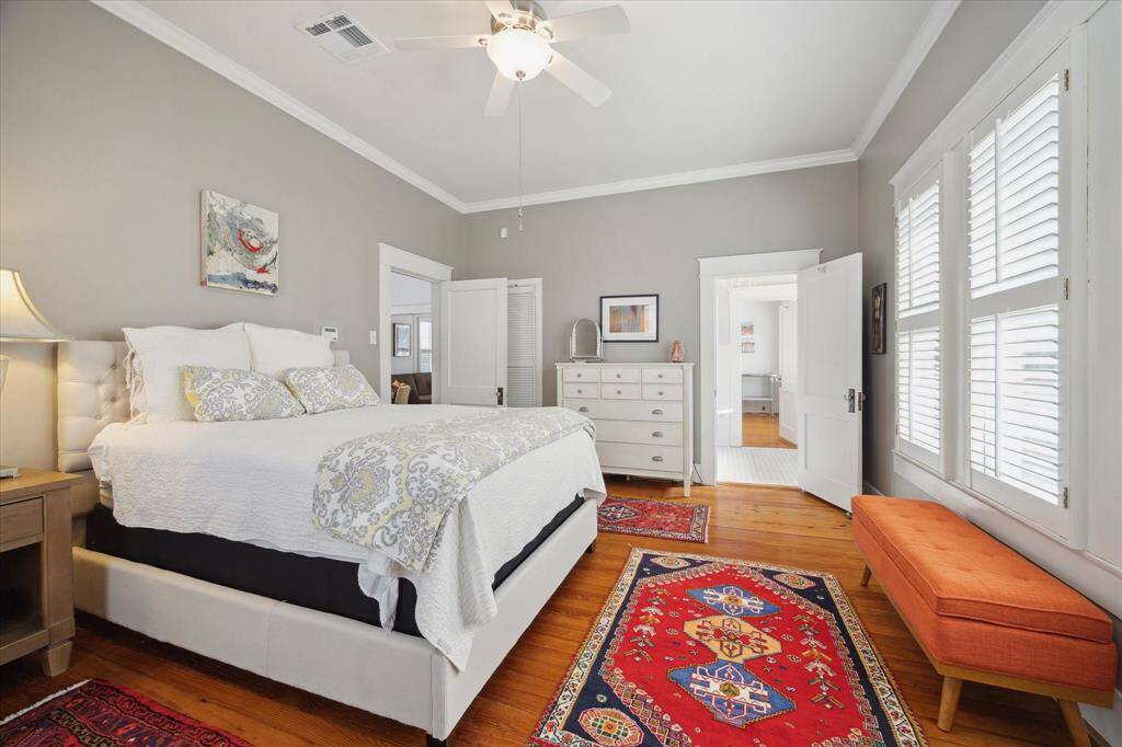 Another view of the beautiful primary bedroom, highlighting the entrance from the dining room and the doorway leading into the bathroom.