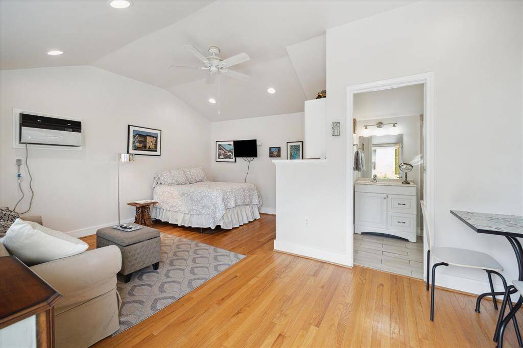 The guest house is a fantastic space, offering room for a sleeping area, a cozy sitting nook, and even a dining area— terrific for guests or extra living space.  Notice the high ceiling, recessed lighting and ceiling fan.
