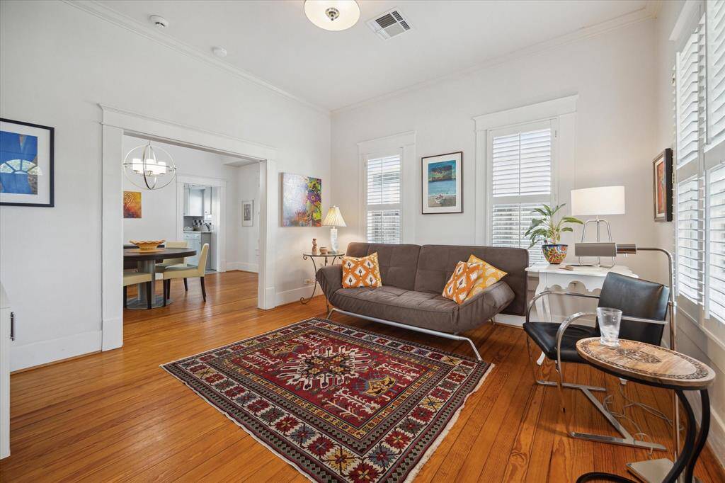 As you step inside, you'll be greeted by the beautiful, original wood floors and the abundance of natural light streaming through the large windows. The ceiling height and wide openings add to the open and spacious feel of the home,  We love the plantation shutters!