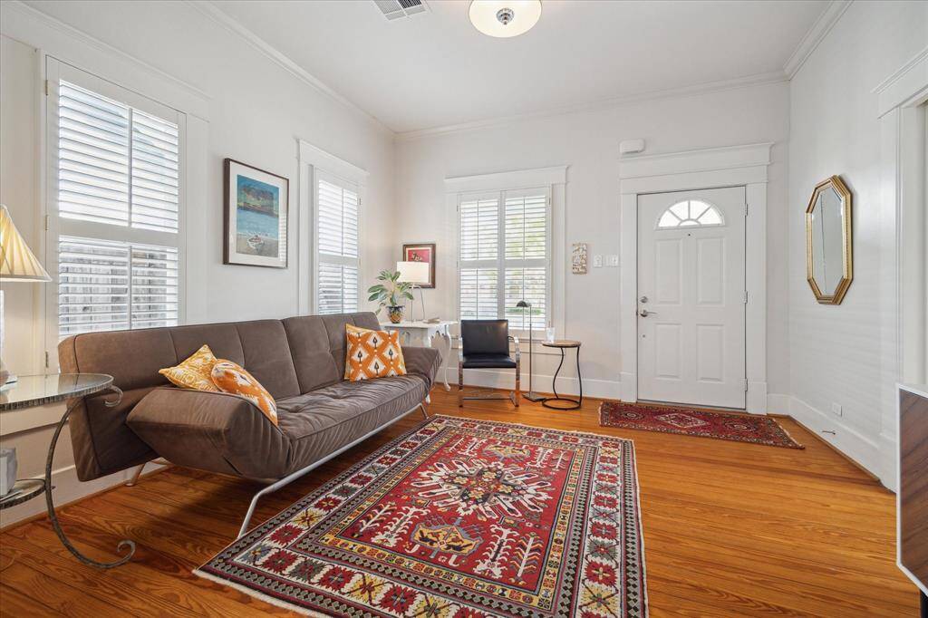 The spacious living room boasts crown molding, high ceilings, and exquisite woodwork around the doors and windows.