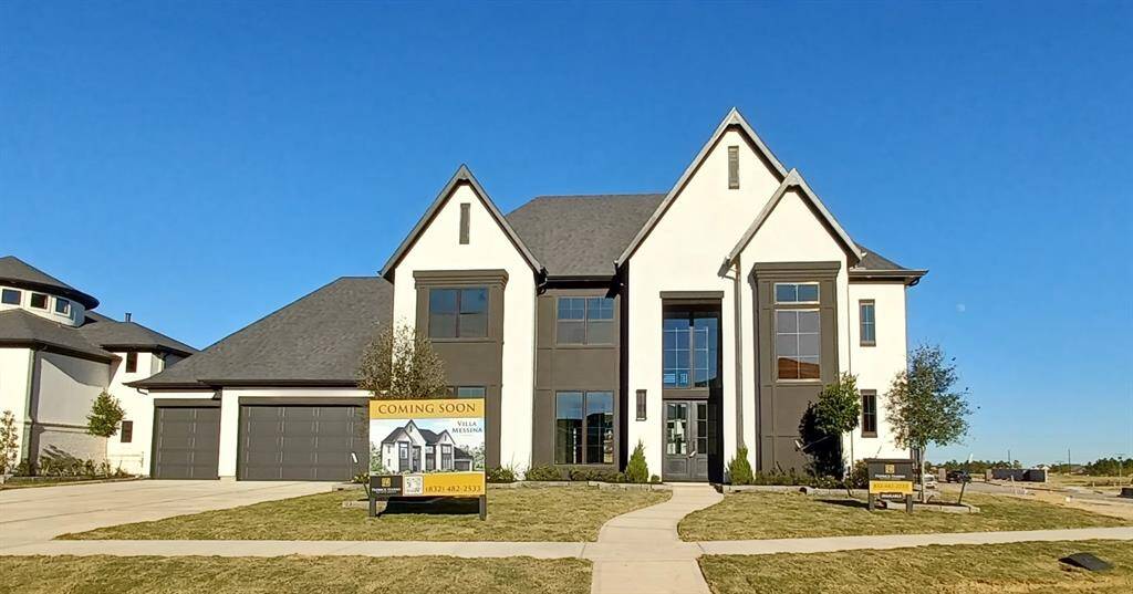 Stunning elevation of the front of this VILLA MESSINA plan by FEDRICK HARRIS with stucco, an array of windows to let light flow in as well as gorgeous iron double front doors to welcome you in.