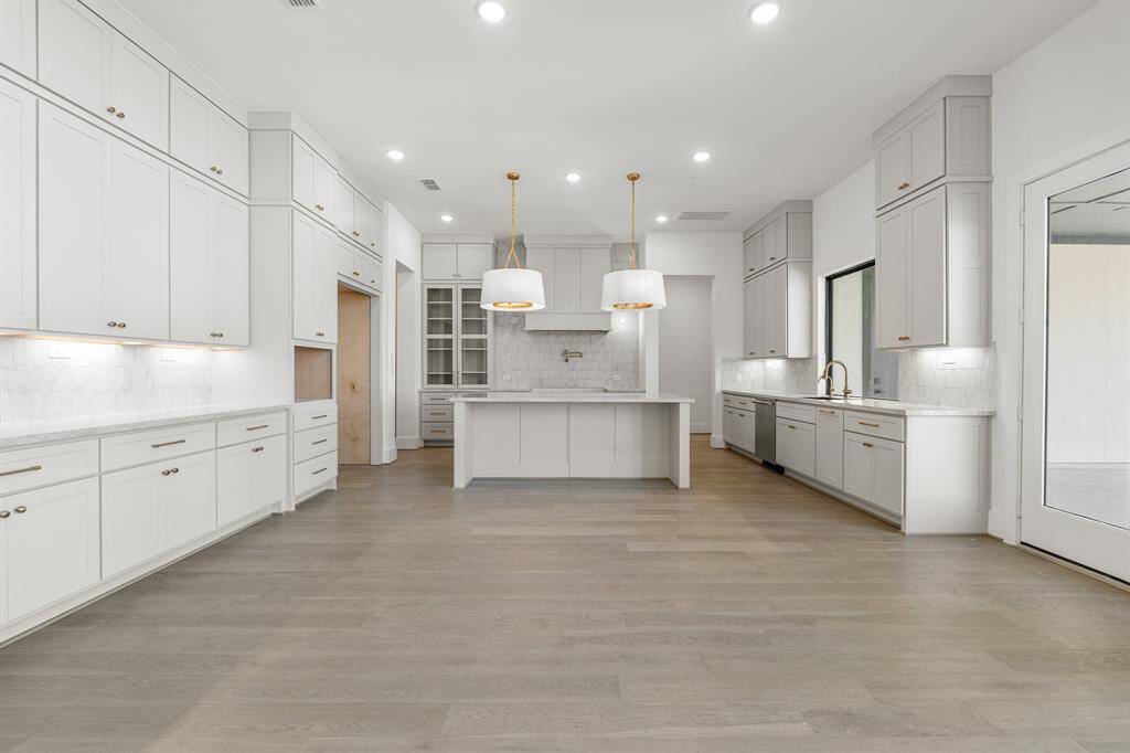 The kitchen features high-end finishes, with sleek porcelain countertops and custom cabinetry. State-of-the-art appliances are seamlessly integrated, adding both function and sophistication. The elegant lighting and designer fixtures elevate the space, creating a truly opulent cooking environment. Gorgeous, engineered hardwood flooring flows throughout.