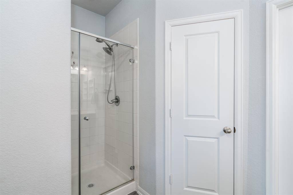 The primary bath also boasts a glass enclosed walk-in shower and two spacious walk-in closets.