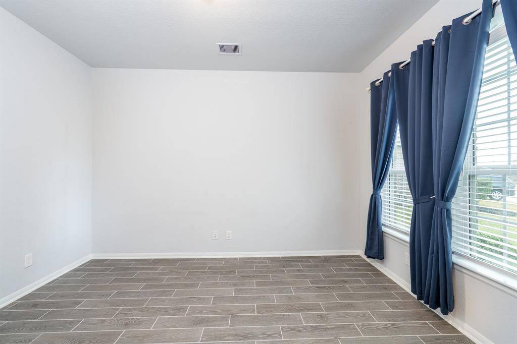 Just off the entry is the private study with French doors, a wall of windows, neutral paint and wood tile flooring, all ready for you to make this space your own!