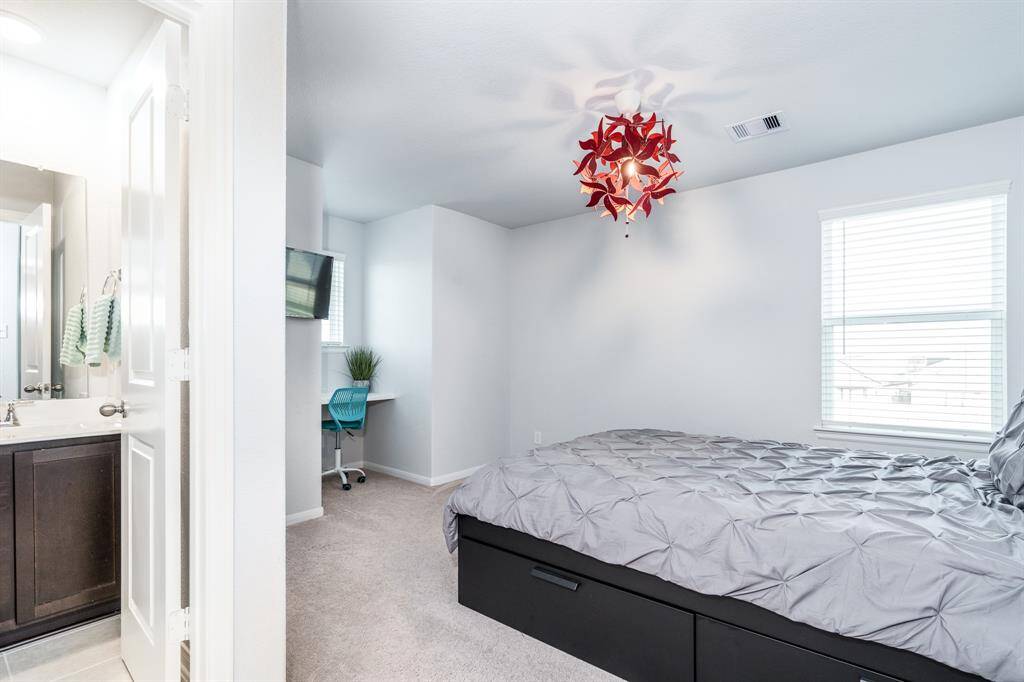 The first of 3 secondary bedrooms features a built-in desk and connecting full bath! It offers just the right place for guests or residents seeking their own private space!