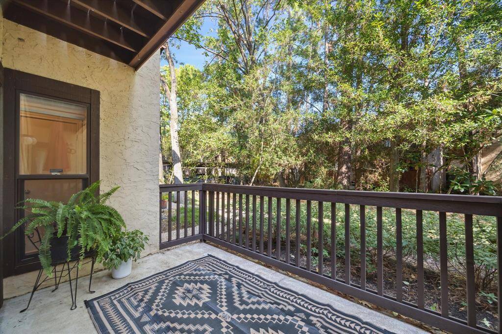 Patio off living room overlooks wooded courtyard.