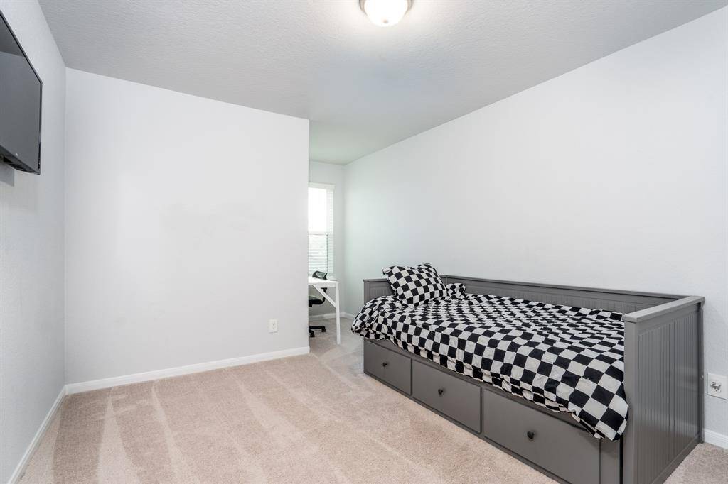 The third of three secondary bedrooms with neutral paint and carpet, walk in closet and a perfect niche for studying or reading!