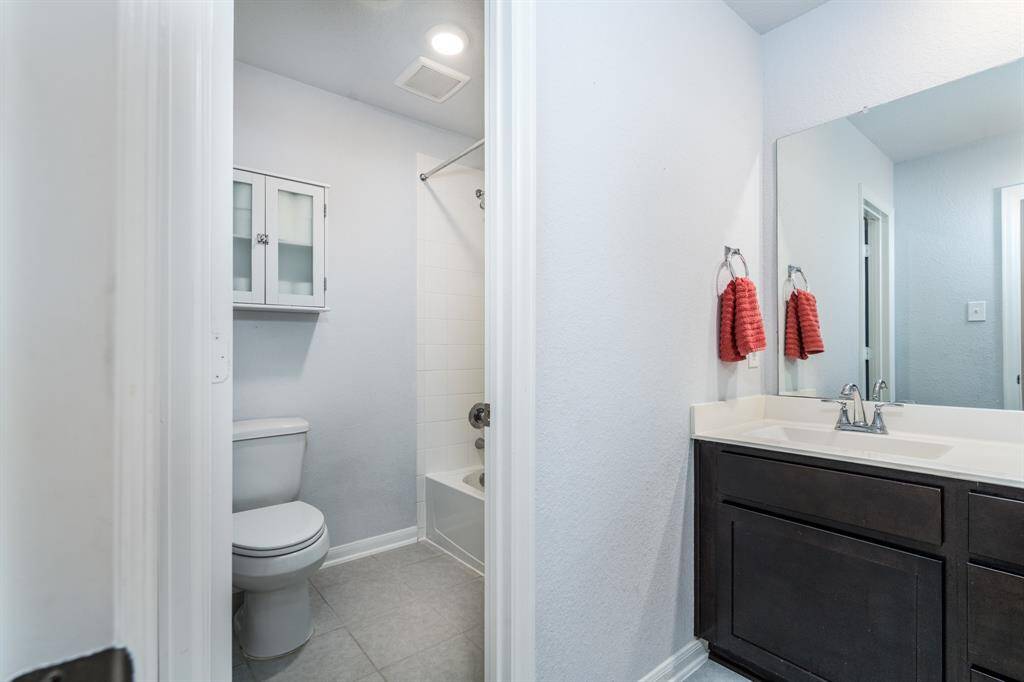 Another full bath boasts a vanity with dual sinks and ample storage, a shower/tub combo with tile surround, and plenty of room to freshen up!