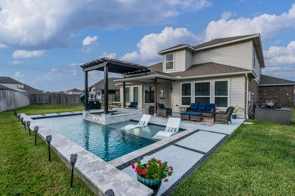 This sparkling pool and spa feature a lovely mosaic tiled raised wall, stacked stone, travertine surround, and spacious sunshelf! Imagine twilight swims in this magical oasis! What's not to love?