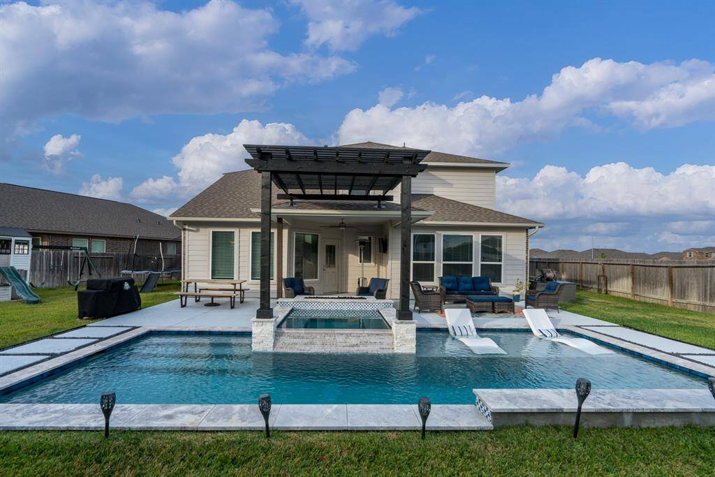 Another view of your backyard paradise showcases the pergola and covered patio, just the right place to beat the Texas heat!