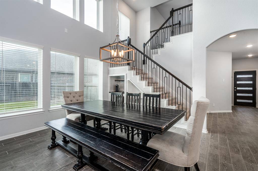 Another view of the dining area highlights the gorgeous staircase with wrought iron balusters and the modern yet sophisticated accent lighting!